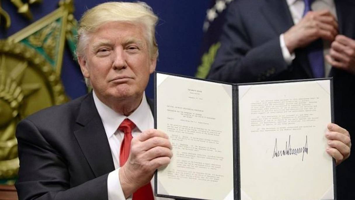 Le président américain Donald Trump montrant son décret migratoire. 
