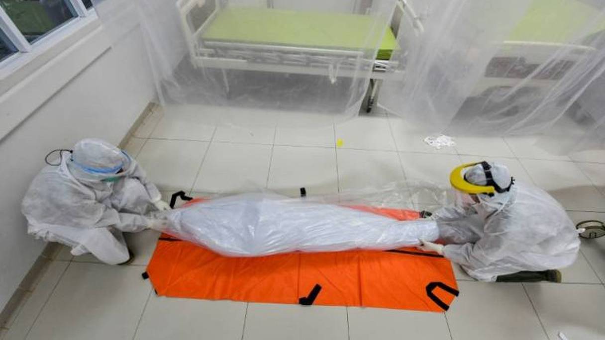 Le corps d'un patient décédé du Covid-19 est emmené par des employés funéraires dans un hôpital de Bogor, en Indonésie, le 9 septembre 2020. 
