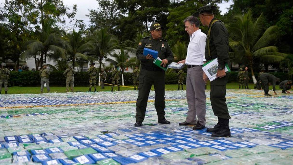 Juan Manuel Santos converse avec un membre d'une unité antinarcotiques alors qu'il marche sur 12 tonnes de cocaïne.
