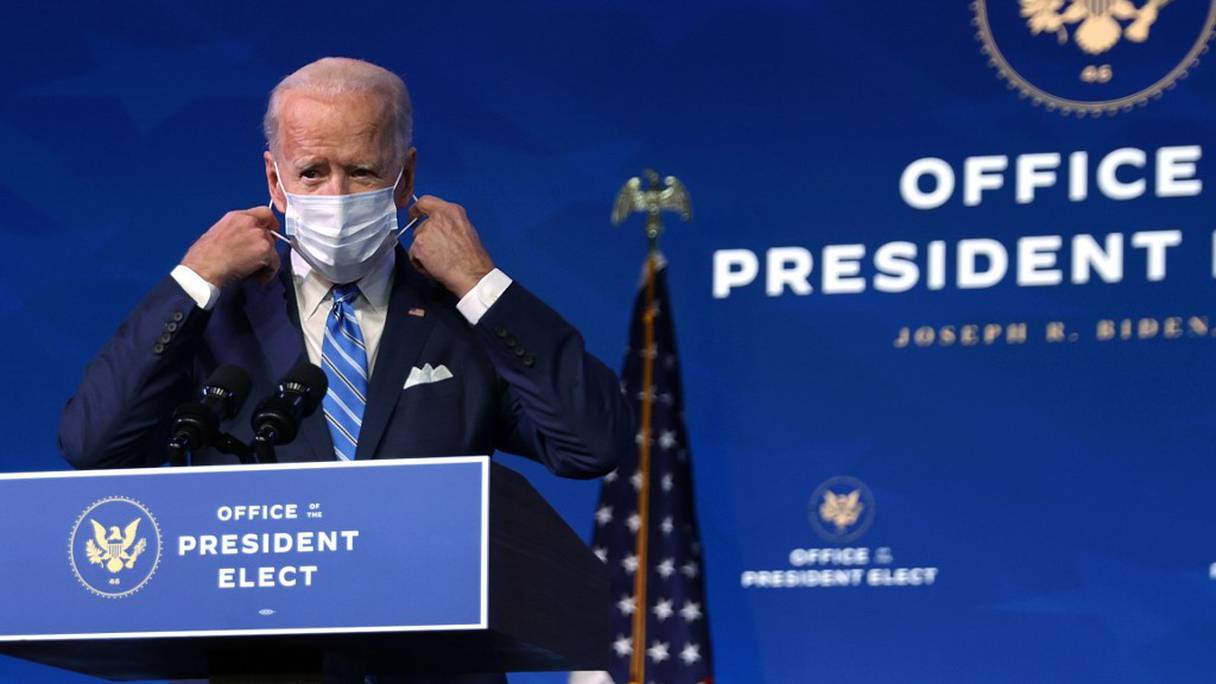 Le président élu Joe Biden ajuste son masque sanitaire à son pupitre, au Queen Theater de Wilmington (Delaware), le 14 janvier 2021. 
