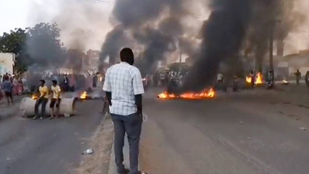 Des manifestants brûlent des pneus et bloquent une route à Khartoum, le 25 octobre 2021, dénonçant les détentions nocturnes par l'armée de membres du gouvernement. Les forces armées ont arrêté le Premier ministre, qui refuse de soutenir leur "coup d'Etat".
