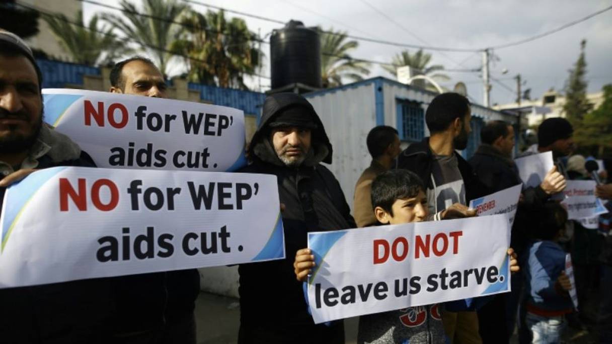 Des Palestiniens manifestent contre les baisses de l'aide internationale, devant les locaux de l'ONU à Gaza.
