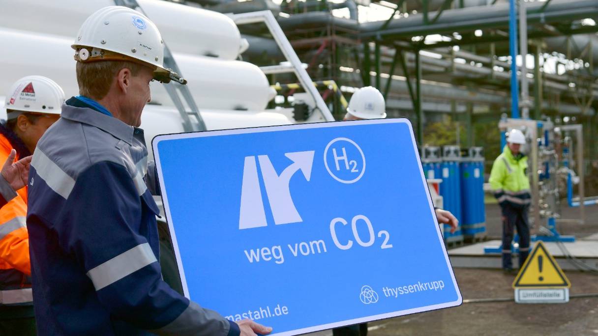 Des employés portent une plaque indiquant «S'éloigner du CO2» au haut fourneau de production d'acier de ThyssenKrupp à Duisbourg, dans l'ouest de l'Allemagne, le 11 novembre 2019.
